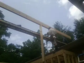 Carpenter setting a ridge beam over a new addition frame — Ice Dam Removal by Roofing Brothers in Fountain
